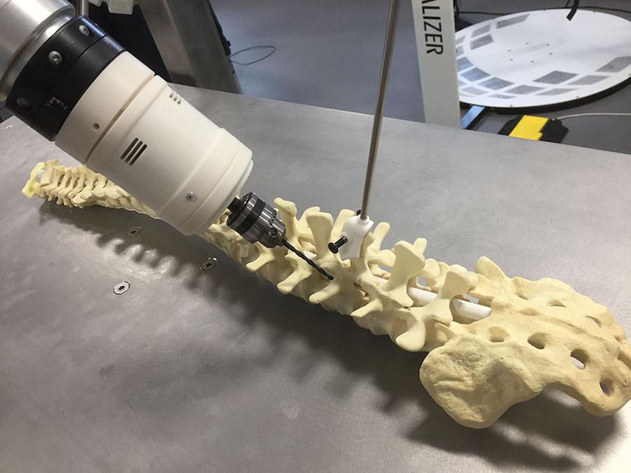 Photo of Robotic Arm Drilling Holes in Individual Vertebrae.