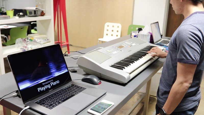 A student tries out the Carnergie Mellon smartwatch that detects hand activity and the smartwatch detects playing the piano